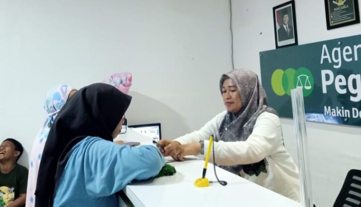 Agen Pegadaian, Elismawanti saat melayani nasabah di outletnya/ FOTO: AGUNG-GOSULSEL