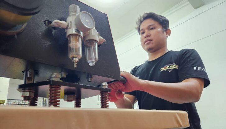 Masturi saat sedang mencetak baju kaos di rukonya/FOTO: AGUNG-GOSULSEL